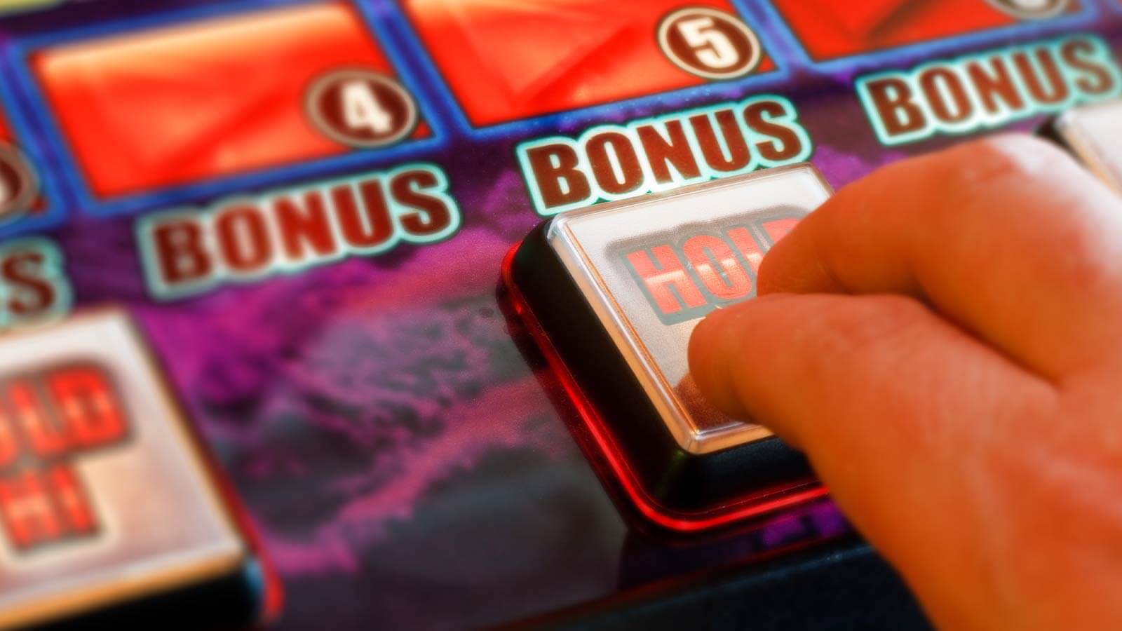 une main activant le bouton bonus d'une machine à sous