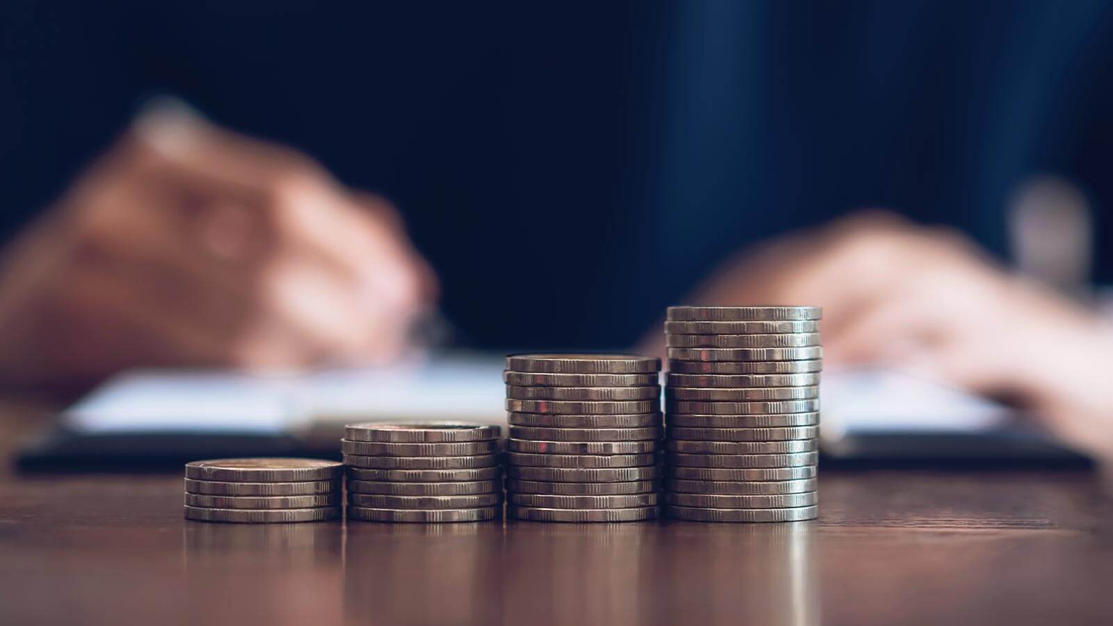 des calculs réalisés devant une pile de pièces