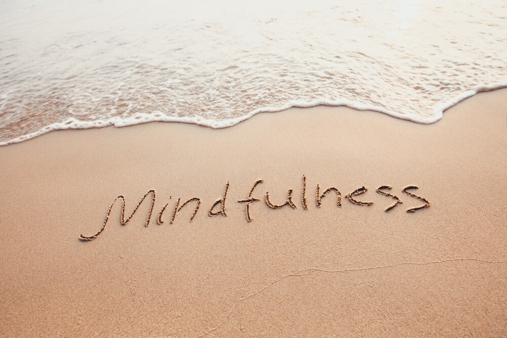 Mindfulness etched into the sand along the beach